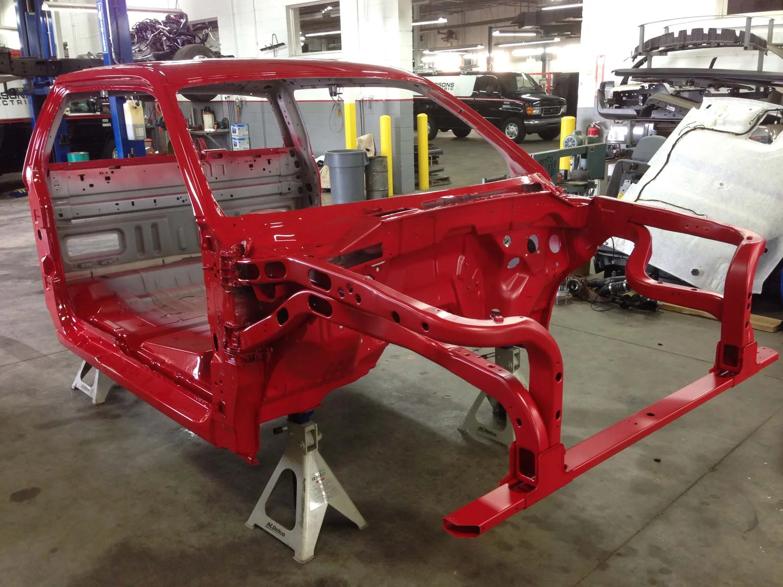 An actual red vehicle cab and frame under repair at Auto Truck Service Co.